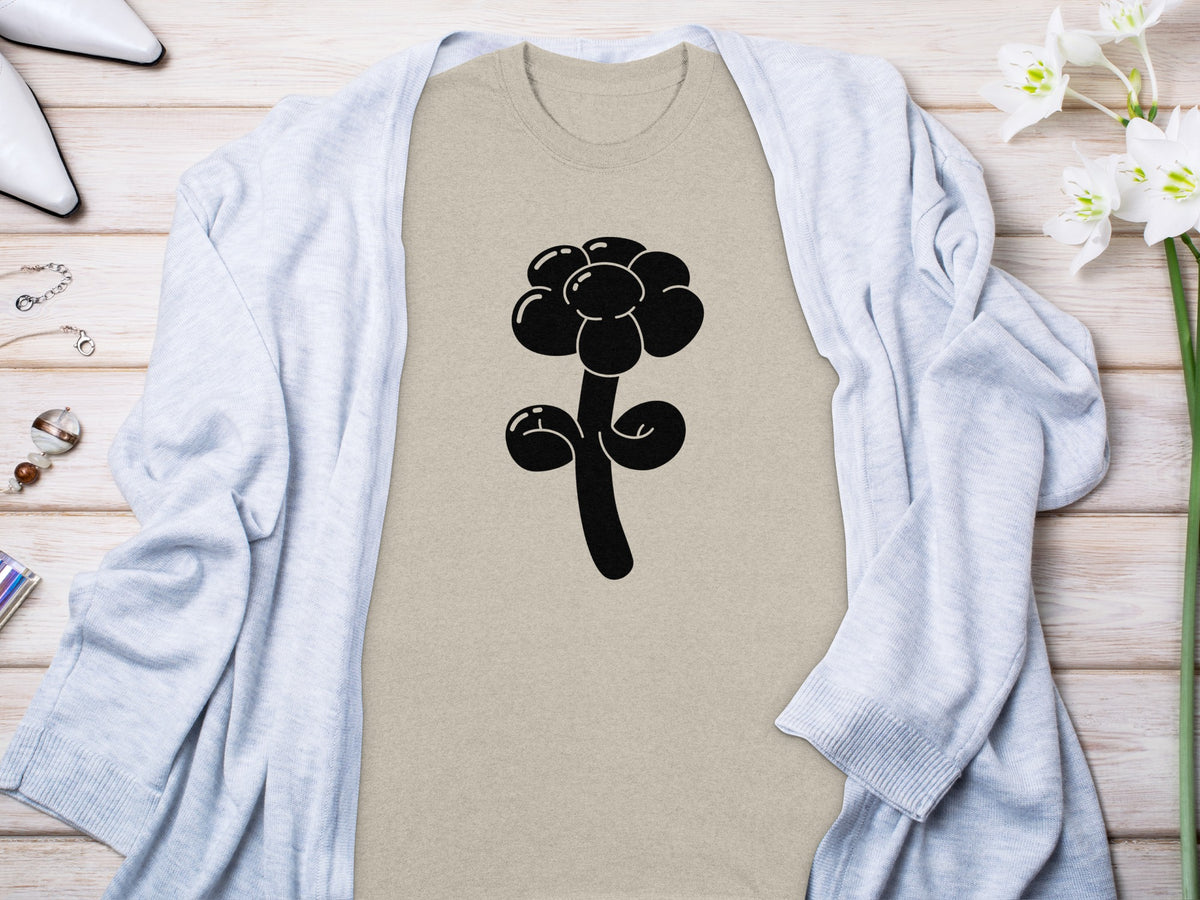 Tan t-shirt with a black balloon flower graphic, styled with a light blue cardigan.