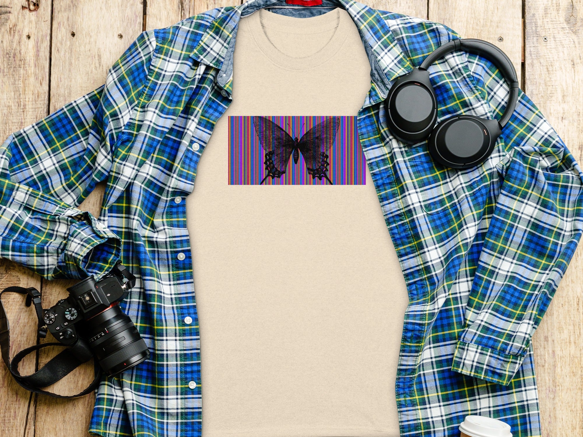 Light tan t-shirt with black butterfly graphic on colorful stripes.