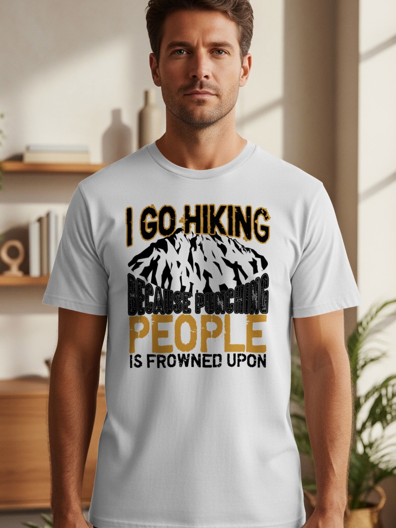 White t-shirt with mountain graphic and text "I go hiking because punching people is frowned upon".