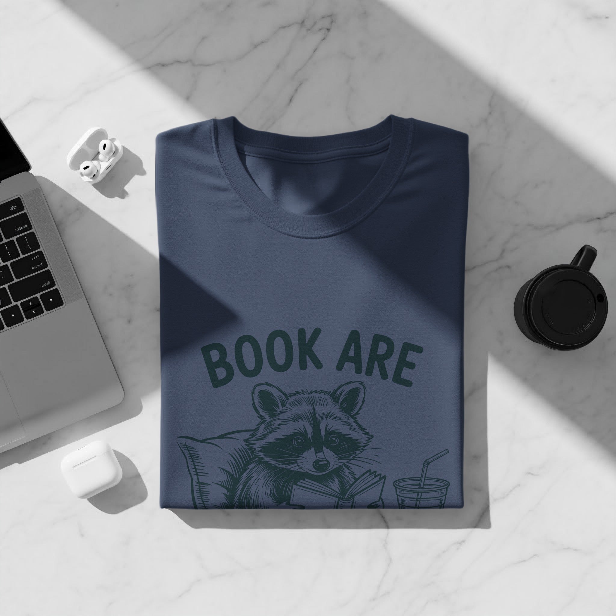 Navy t-shirt with raccoon reading a book and text "BOOK ARE"