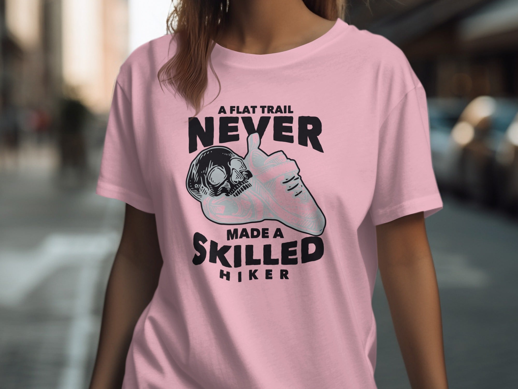 Pink t-shirt with graphic "A flat trail never made a skilled hiker".