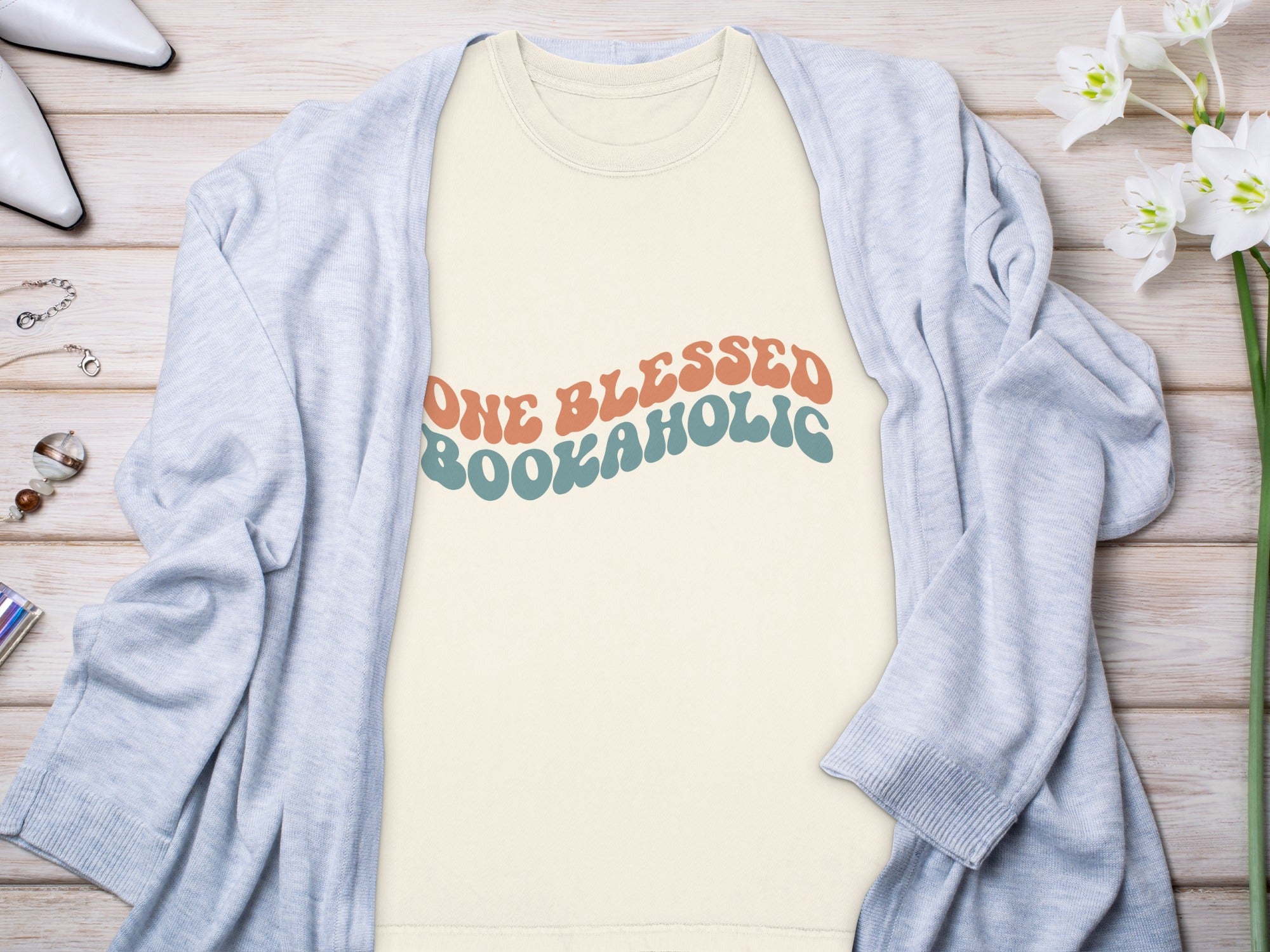 Cream t-shirt with retro "One Blessed Bookaholi" text in coral and teal.