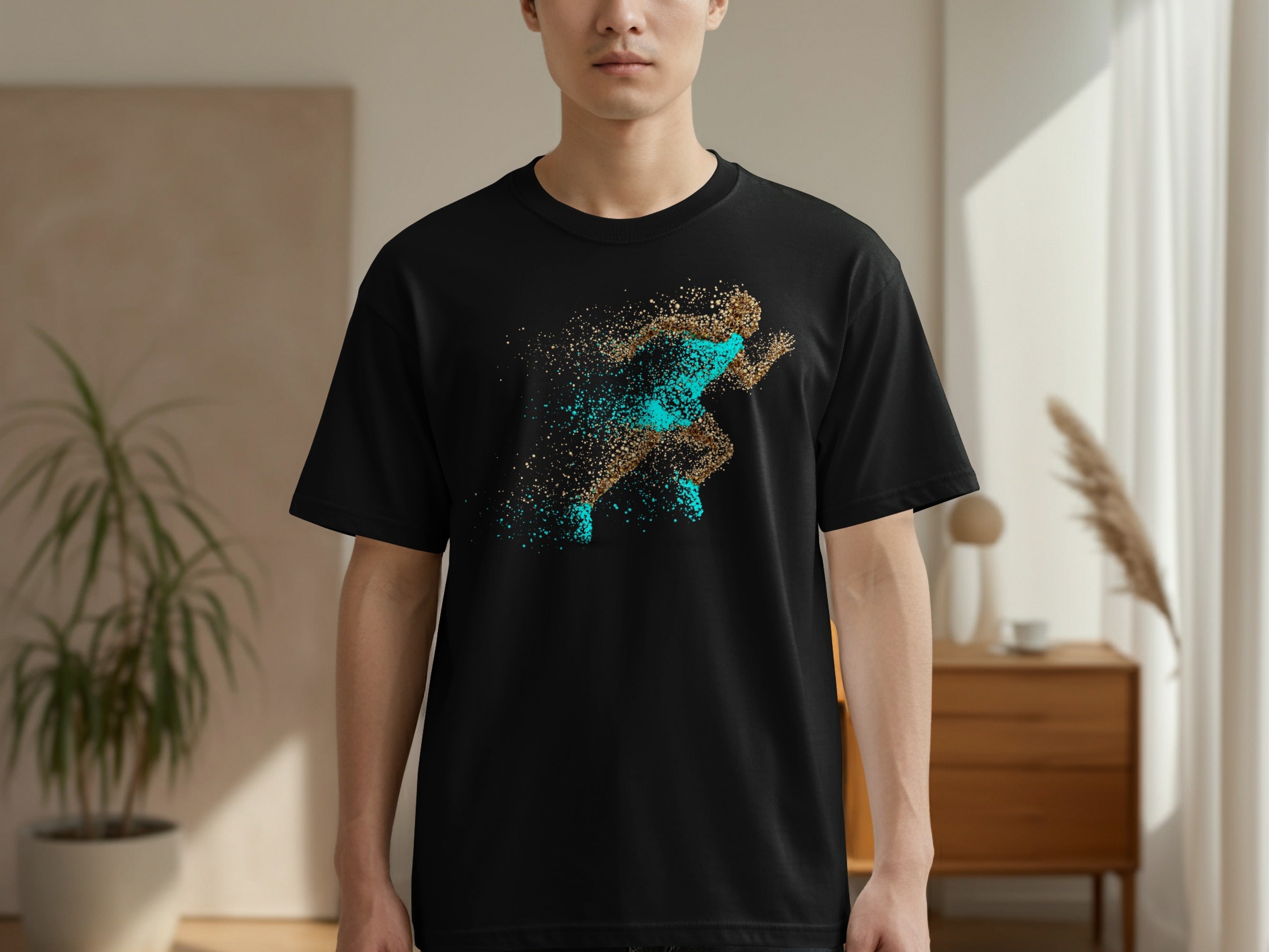 Black t-shirt with a running figure made of sparkling gold and teal particles.
