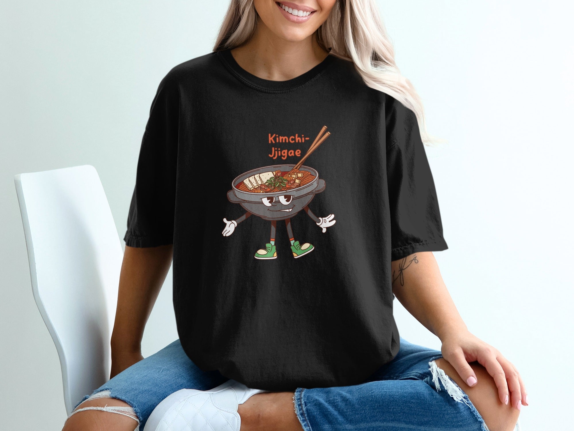 Black t-shirt with cartoon kimchi jjigae graphic and text.