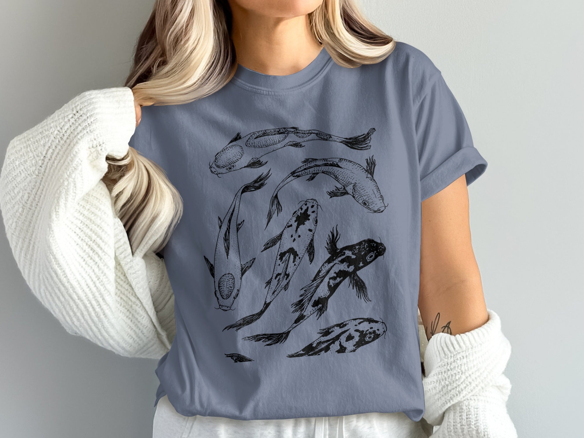 T-shirt with a black outline sketch of five koi fish swimming in a circle.