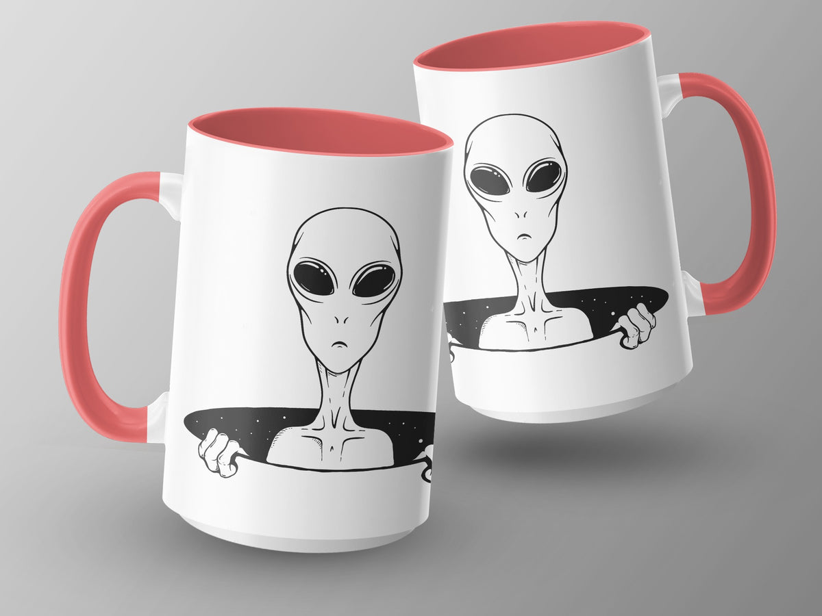 Two white mugs with coral handles, featuring black alien illustrations.