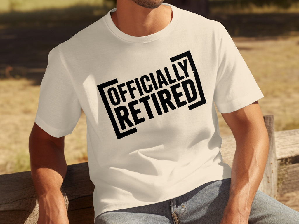 Cream t-shirt with black text that reads "OFFICIALLY RETIRED" in bold, outlined letters.