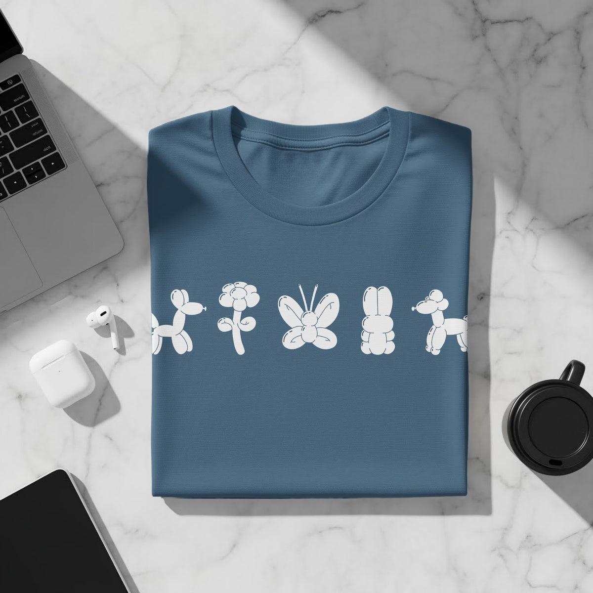 Blue t-shirt with white balloon animal designs: dog, flower, butterfly, bunny, dog.