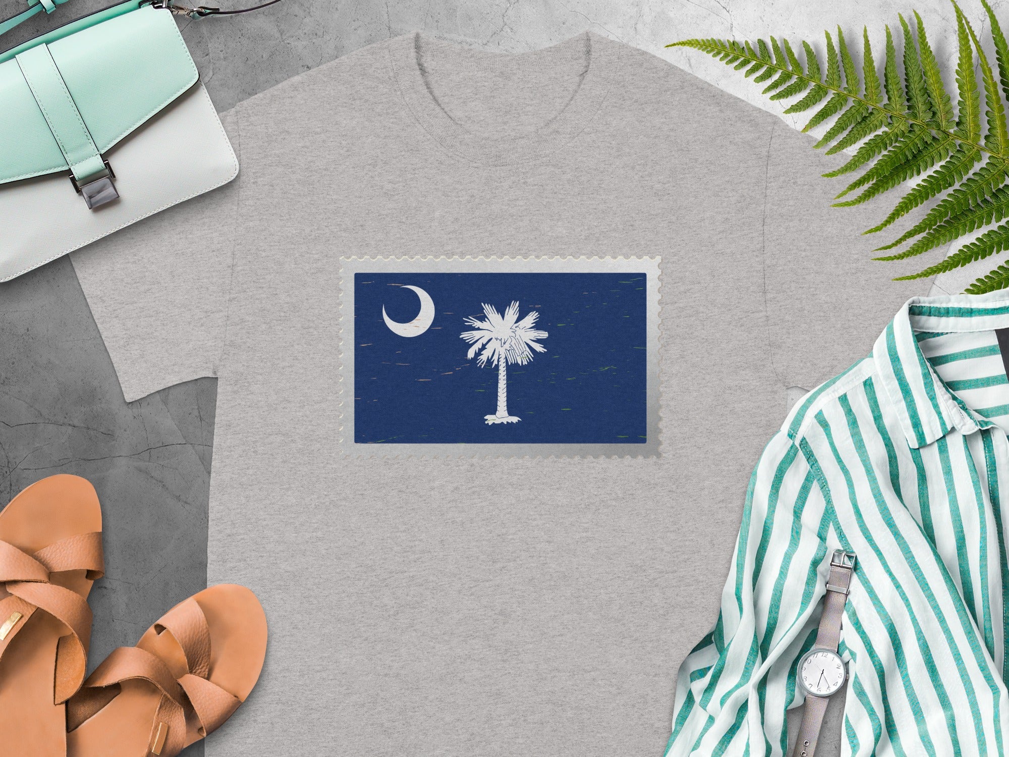 Grey t-shirt with a postage stamp featuring the South Carolina flag emblem.