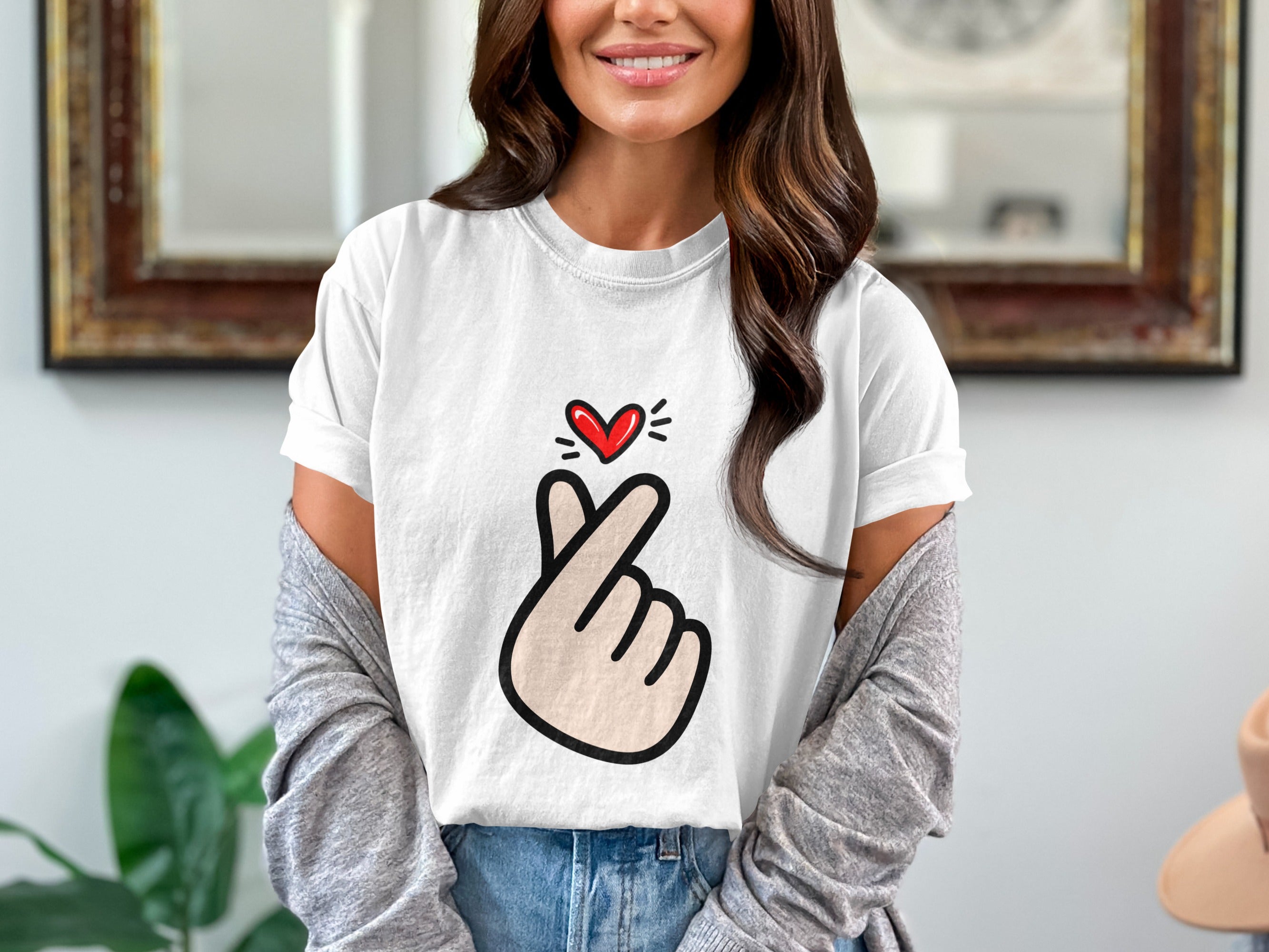 White t-shirt with a red heart gesture graphic on the chest.