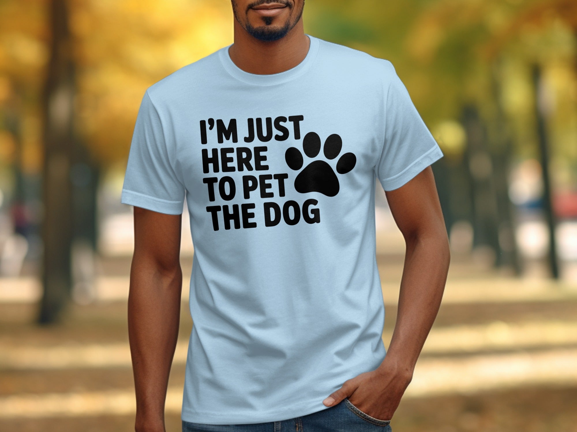 Light blue t-shirt with black text "I'M JUST HERE TO PET THE DOG" and a paw print.