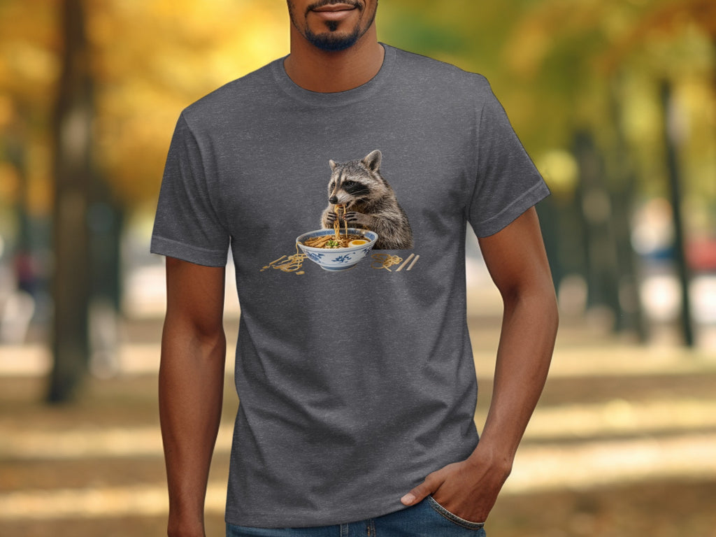 Raccoon eating ramen with chopsticks on a gray t-shirt.