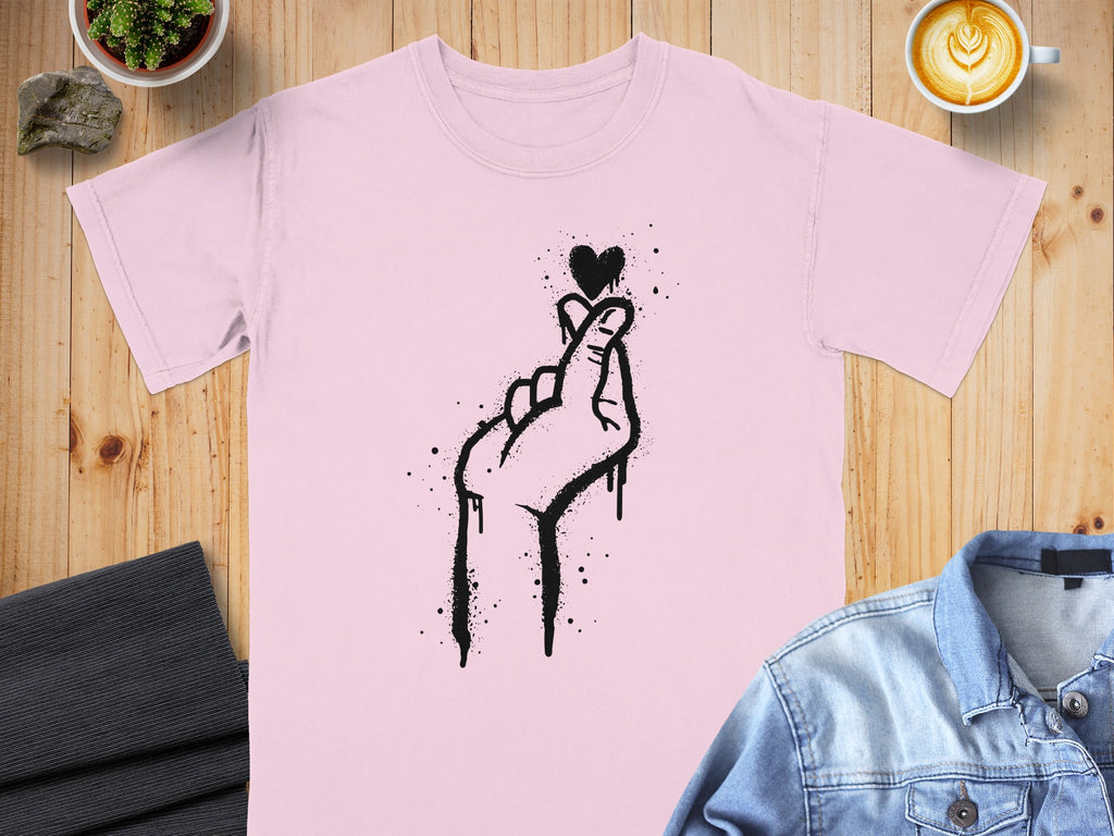 Light pink t-shirt with black spray-painted hand gesture forming a heart