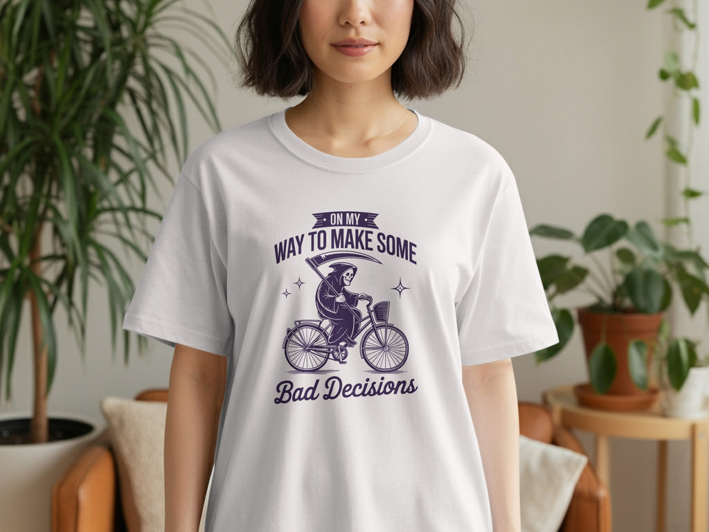 White t-shirt with purple graphic: Grim Reaper on a bicycle, "ON MY WAY TO MAKE SOME Bad Decisions".
