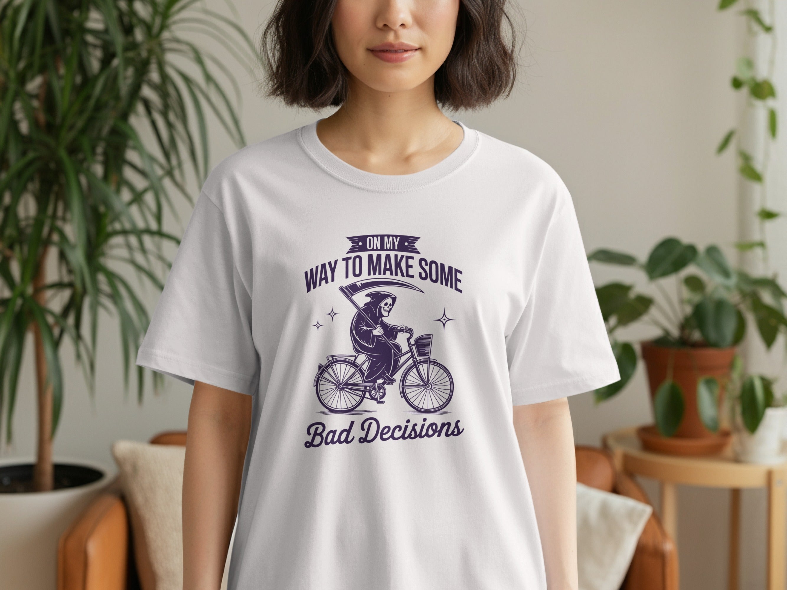 White t-shirt with purple graphic: Grim Reaper on a bicycle, "ON MY WAY TO MAKE SOME Bad Decisions".