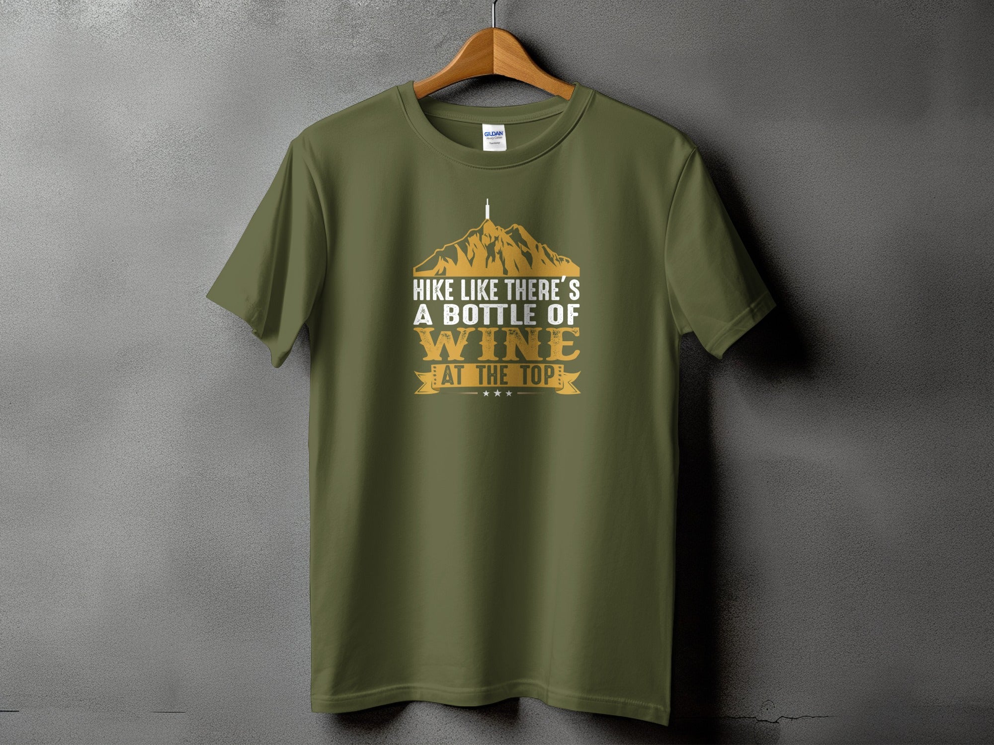 Olive t-shirt with mountains and the text "Hike like there's a bottle of wine at the top."