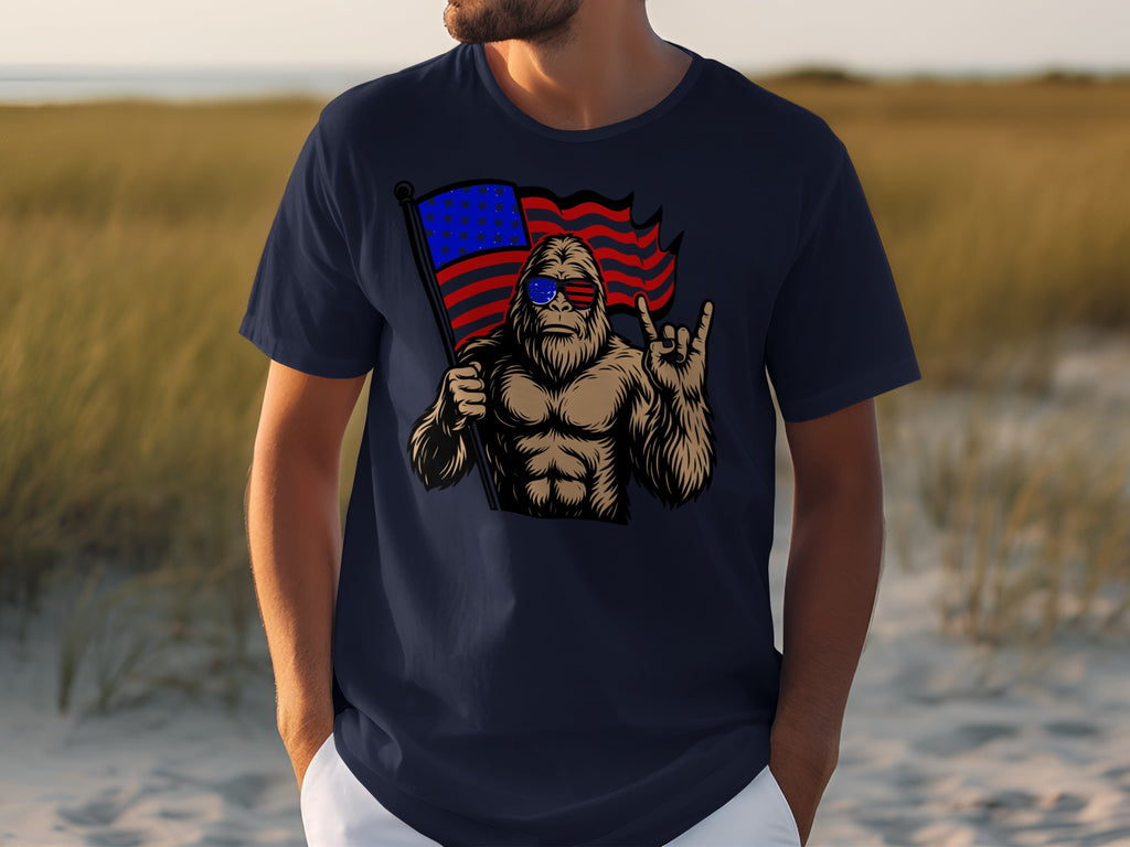 Man in navy t-shirt with graphic of Bigfoot holding American flag and wearing sunglasses.