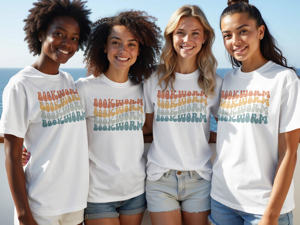 Four women wear white t-shirts with stacked "BOOKWORM" text in retro rainbow colors.
