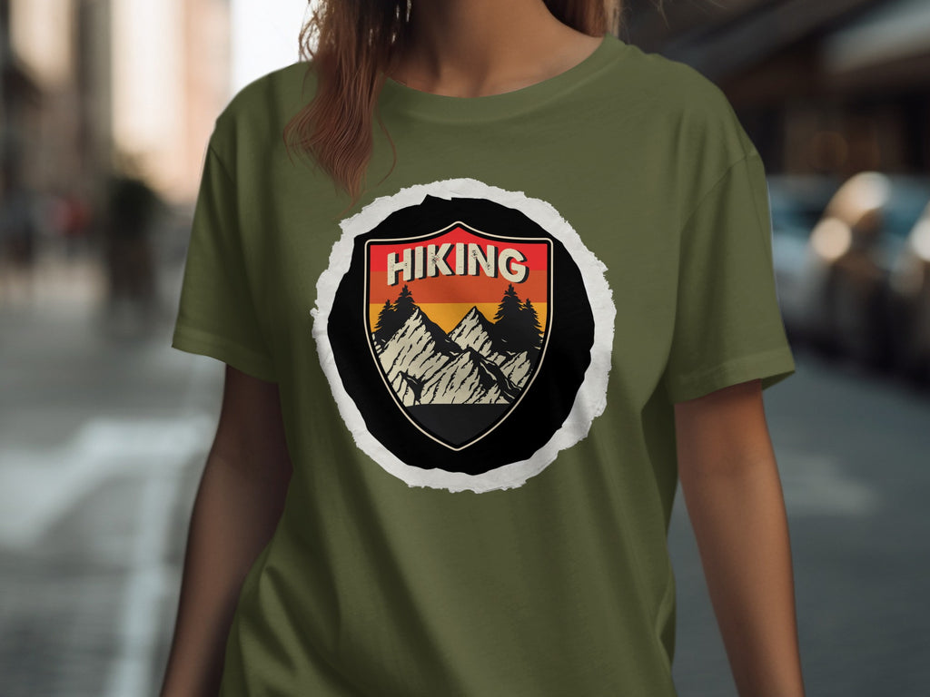 Olive green t-shirt featuring a black shield with "HIKING" text and a mountain landscape.