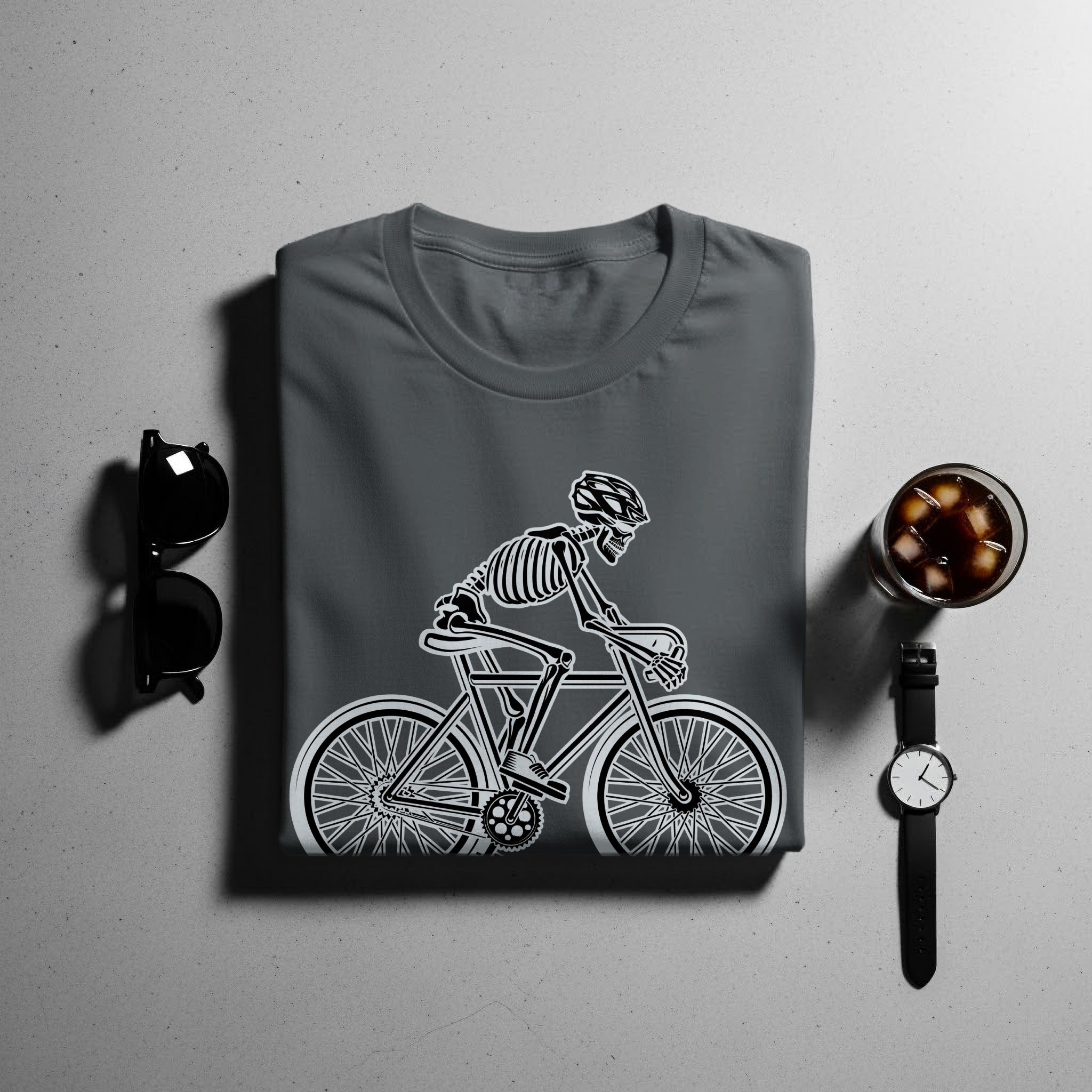 Dark grey t-shirt with a white skeleton riding a bicycle graphic.