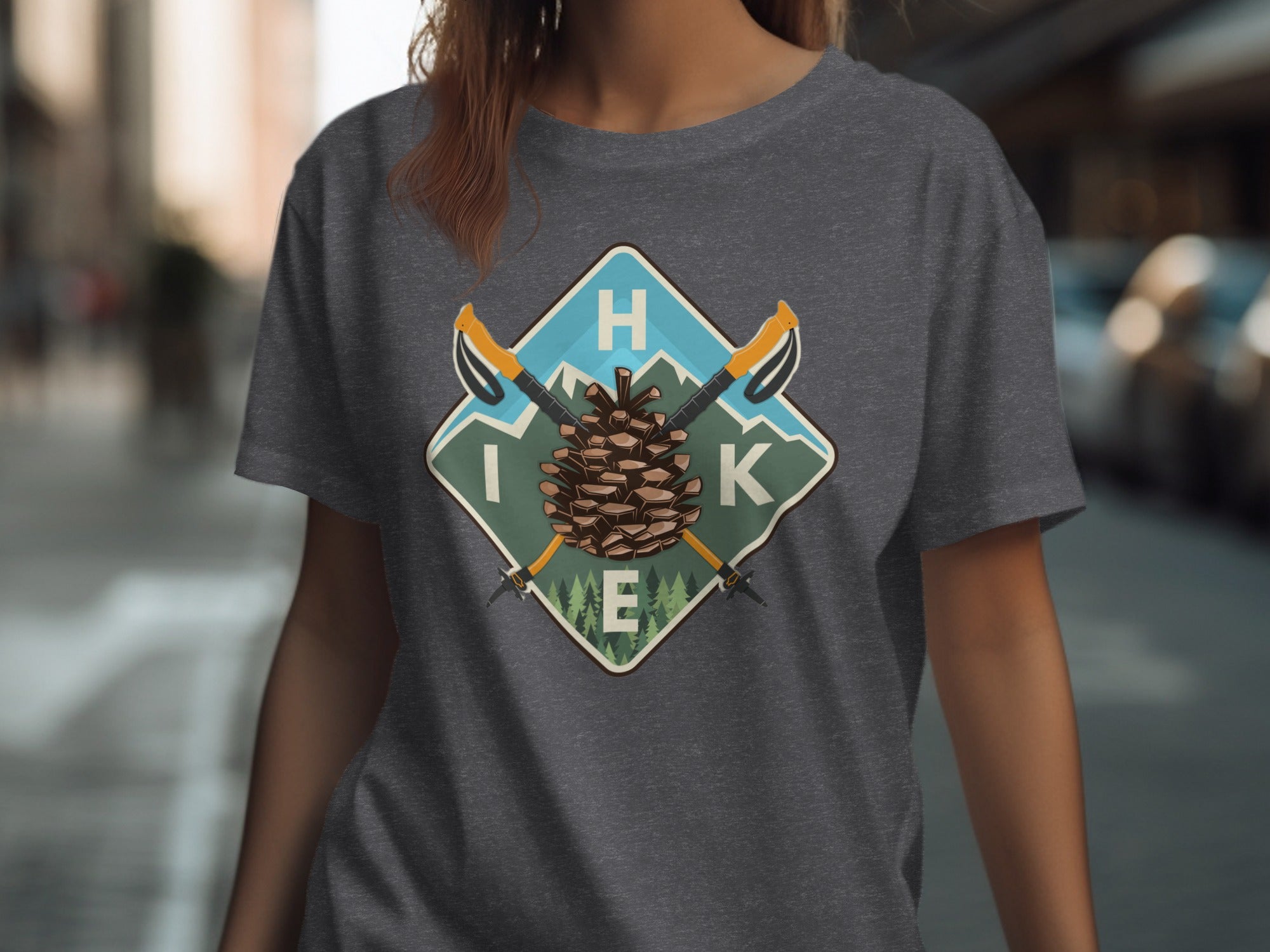 Dark grey t-shirt with a square badge featuring a pine cone, mountains, and hiking poles.