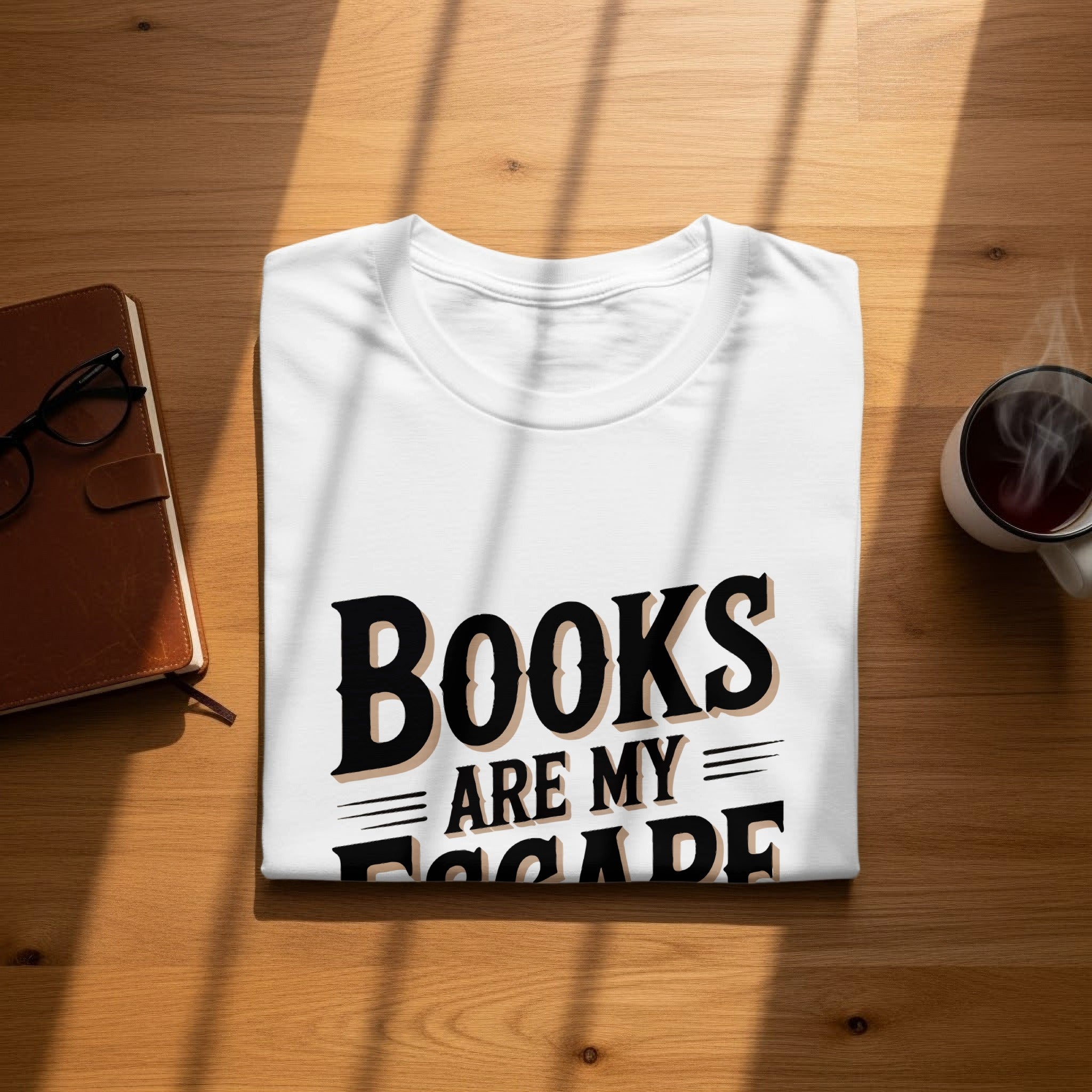 White t-shirt with "Books are my escape" text, notebook, glasses, and steaming mug.