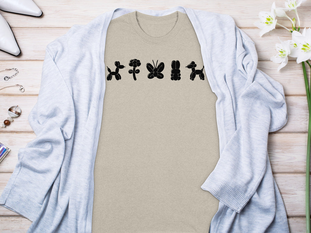 Tan t-shirt with black balloon animals: dog, flower, butterfly, rabbit, dog.