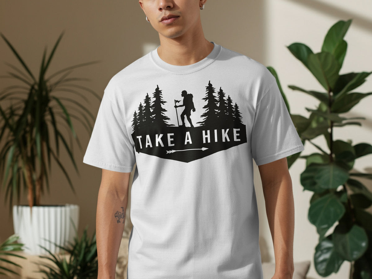 White t-shirt with black graphic of hiker, trees, and text "Take a Hike".