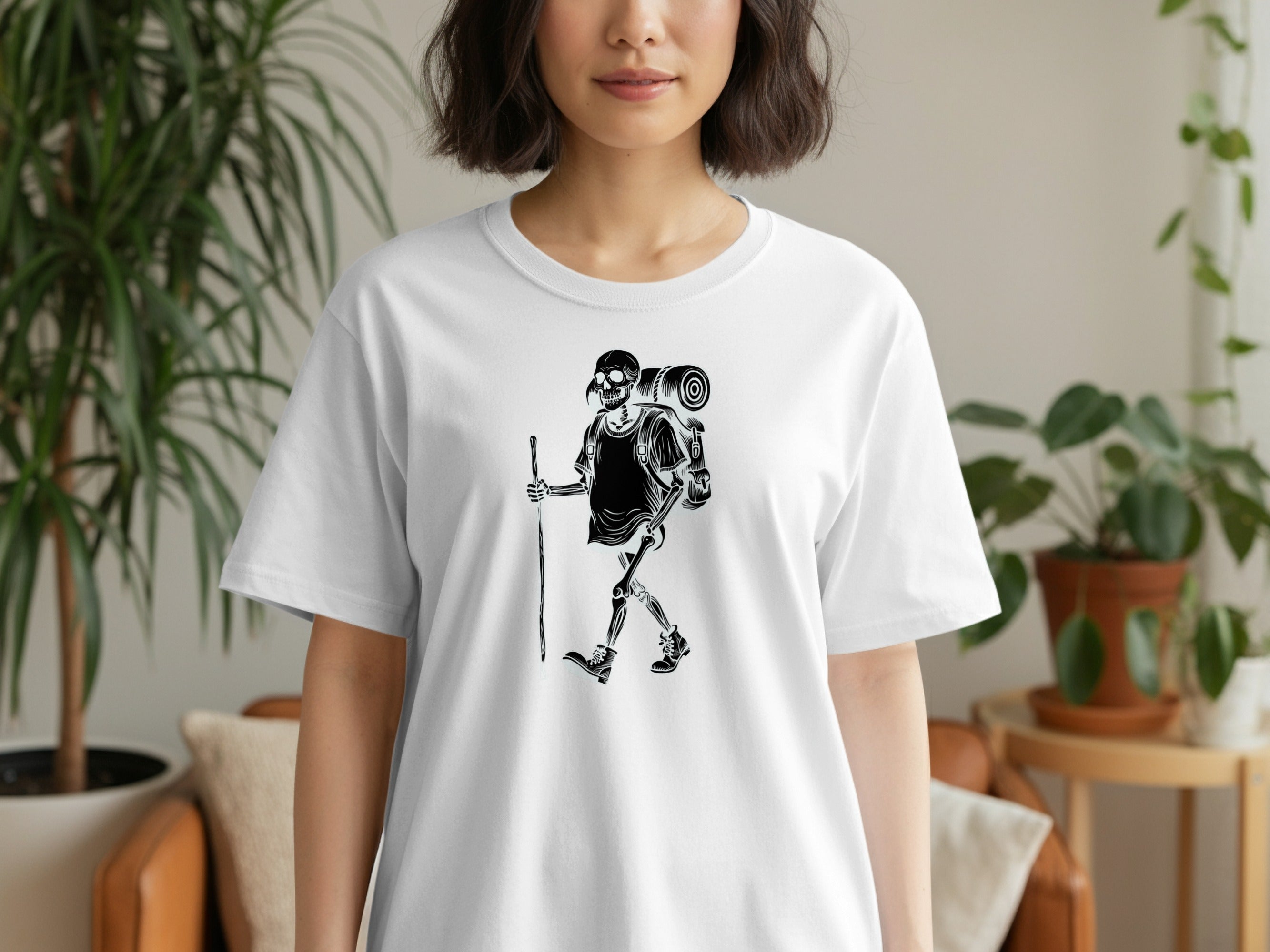 White t-shirt with black graphic of skeleton hiker on a white background.