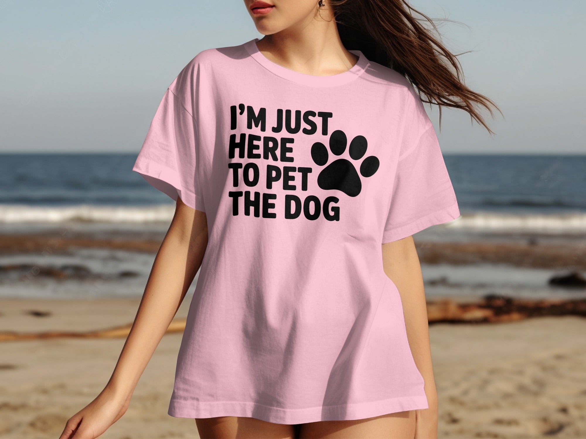 Pink t-shirt with black text "I'M JUST HERE TO PET THE DOG" and paw print.