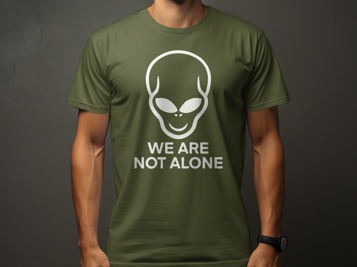 Green t-shirt with white alien head logo and text "WE ARE NOT ALONE".