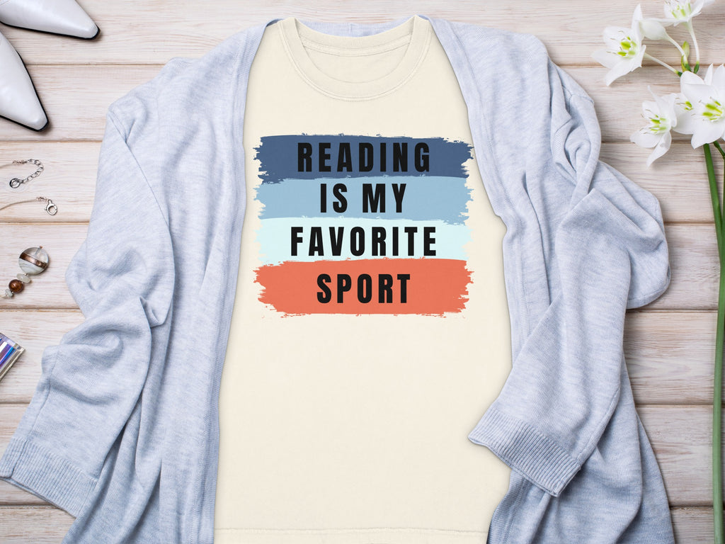 Cream t-shirt with "Reading is my favorite sport" text and colored brush strokes.