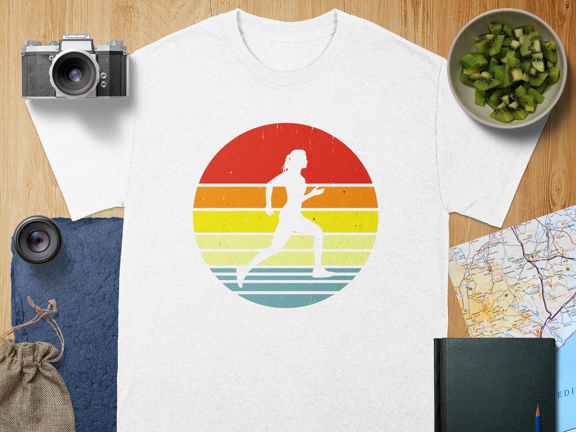 White t-shirt with a vintage runner graphic on a striped sunset background.