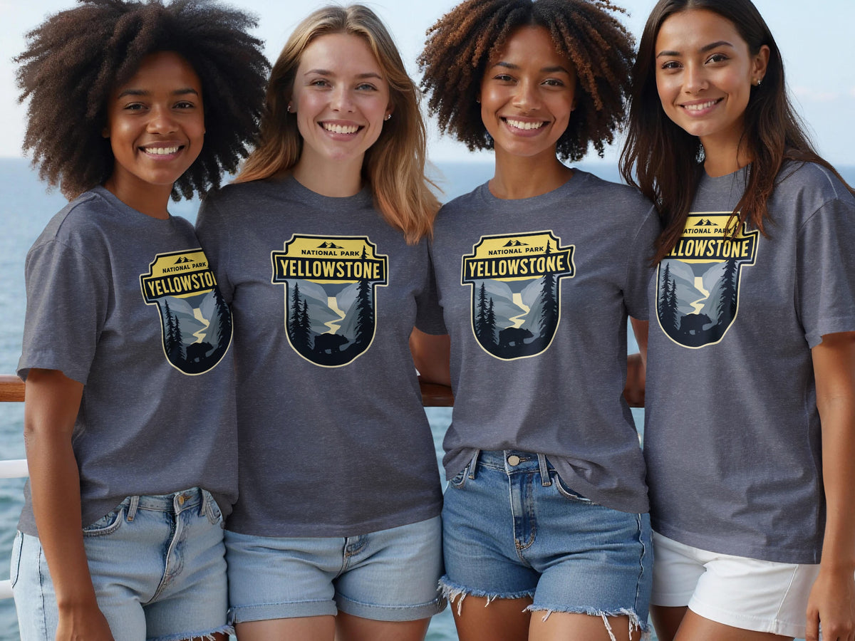 Four women wear grey t-shirts with a Yellowstone National Park design.