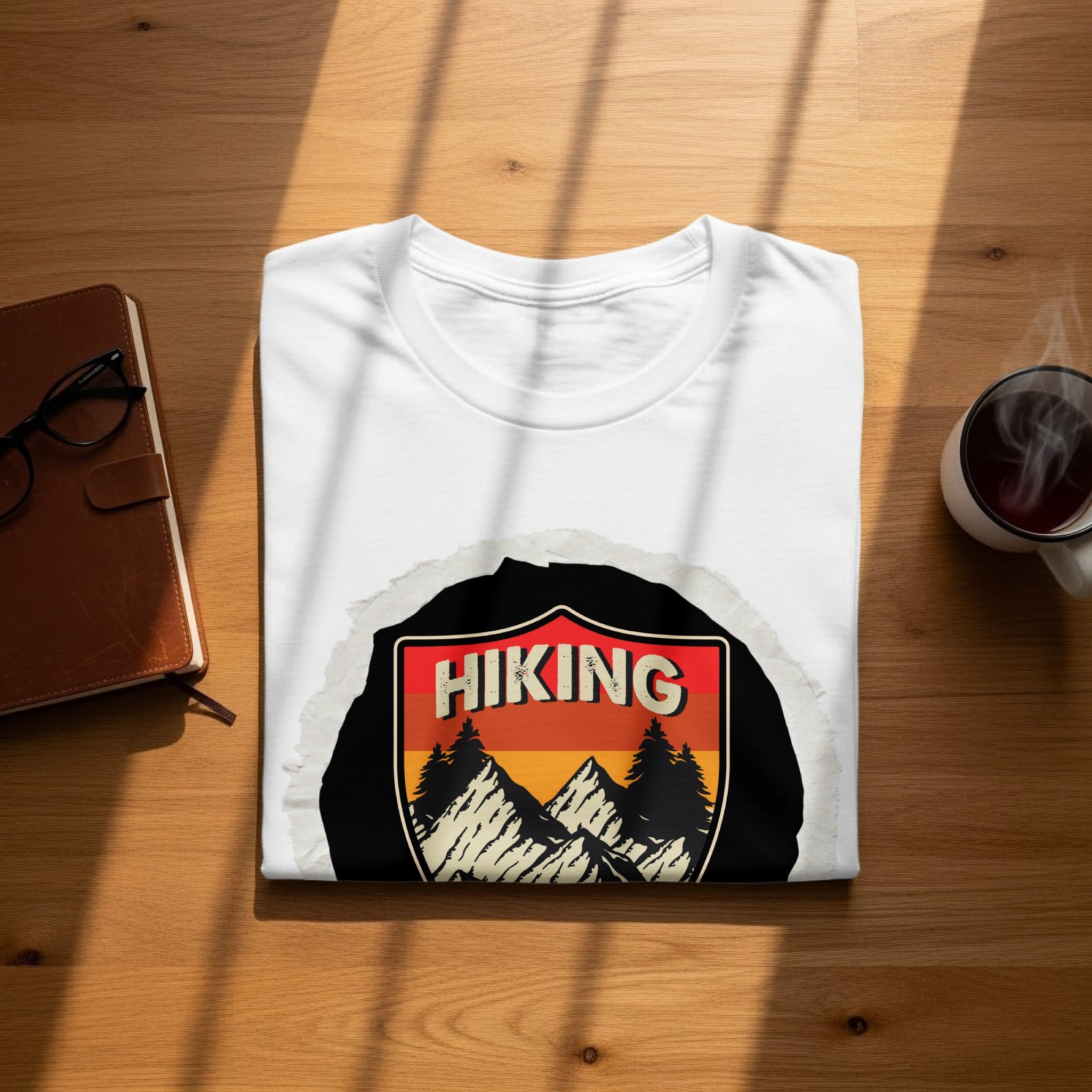 White t-shirt with an emblem featuring "HIKING" above mountains and trees.