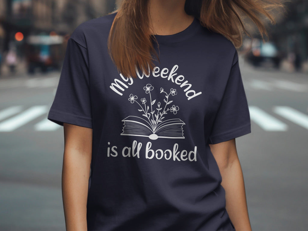 Navy t-shirt with "my weekend is all booked" text and open book with flowers graphic.