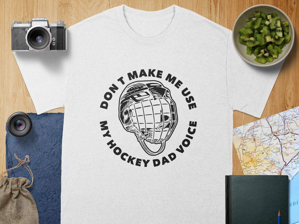 White t-shirt with black hockey helmet graphic and text "Don't make me use my hockey dad voice."
