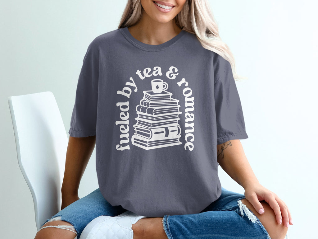 T-shirt with stacked books graphic and text: "fueled by tea & romance"
