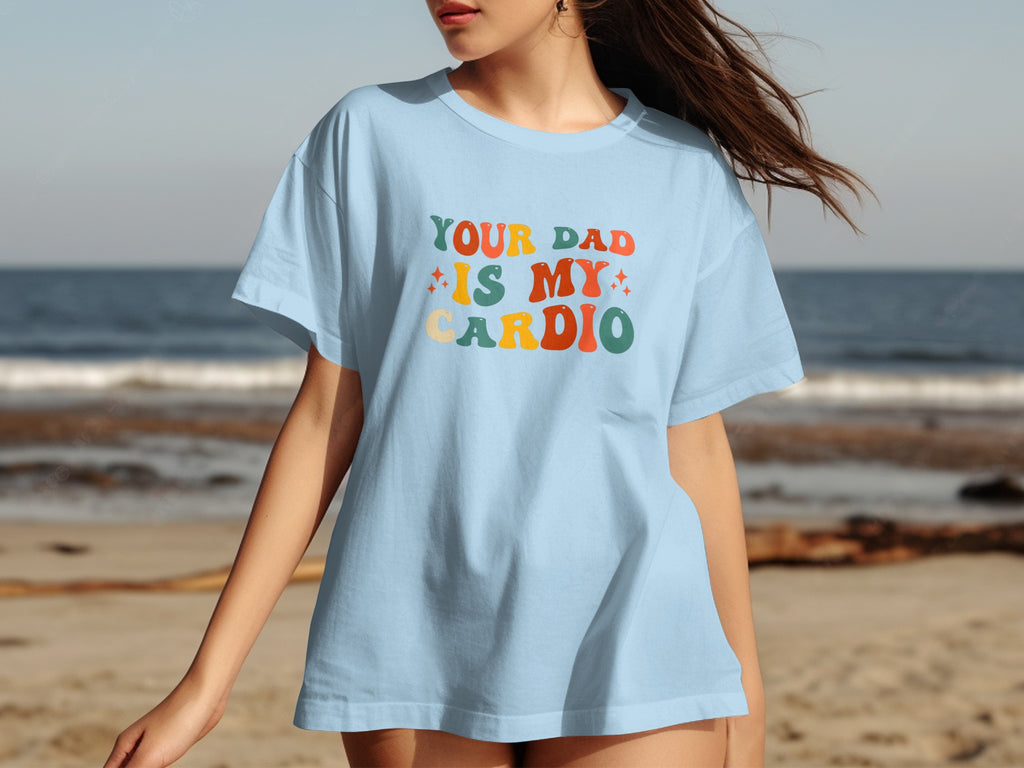 Light blue t-shirt with "YOUR DAD IS MY CARDIO" text in retro lettering.