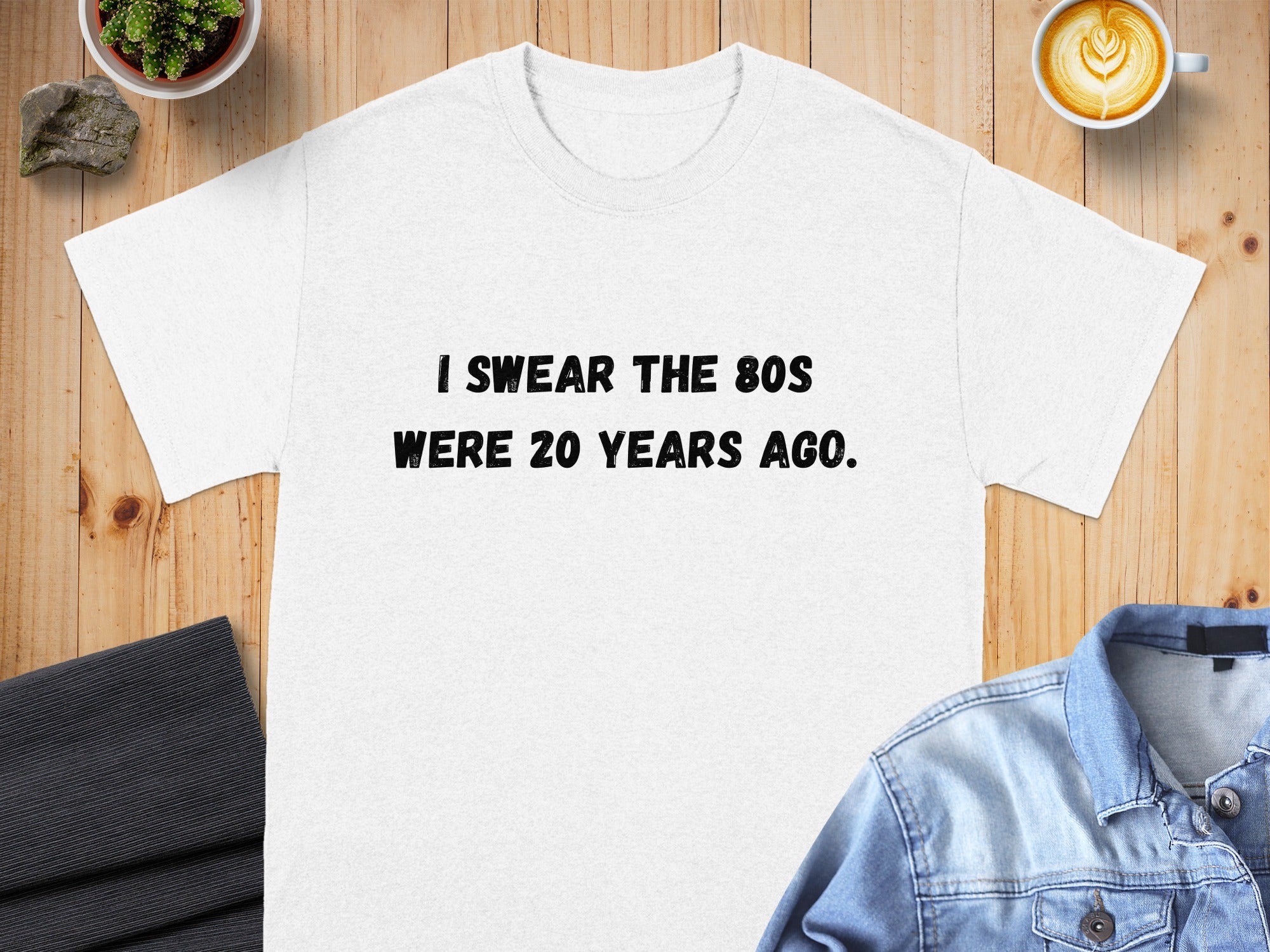 White t-shirt with black text stating "I SWEAR THE 80S WERE 20 YEARS AGO."