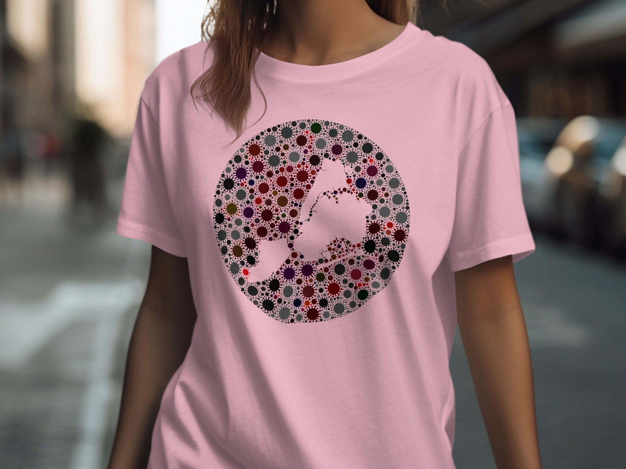 Pink t-shirt with a circular graphic of many small virus shapes forming a broom and witch hat.