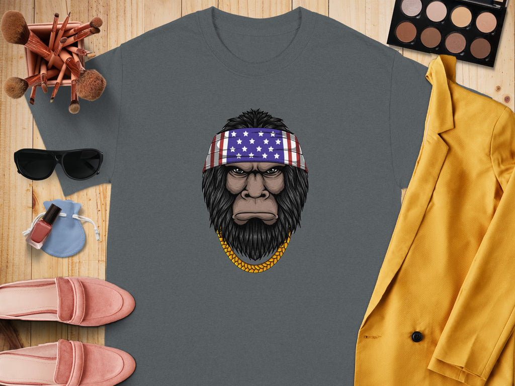 Bigfoot wearing an American flag bandana and gold chain on a gray t-shirt.