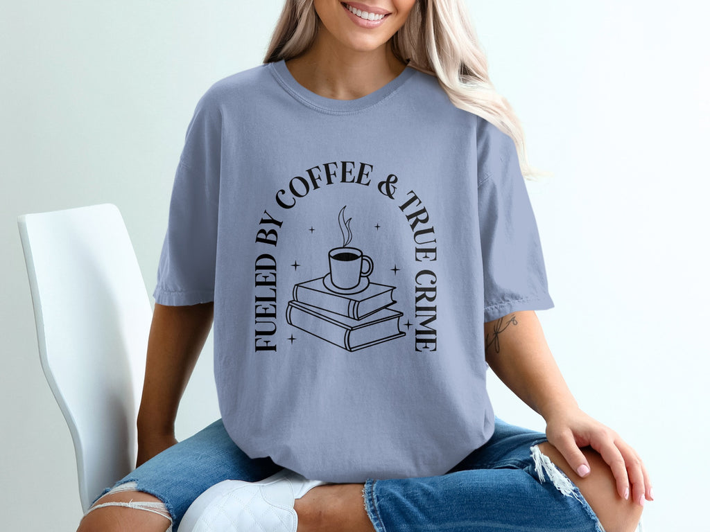 T-shirt with "Fueled by Coffee & True Crime" text and stack of books and coffee mug graphic.
