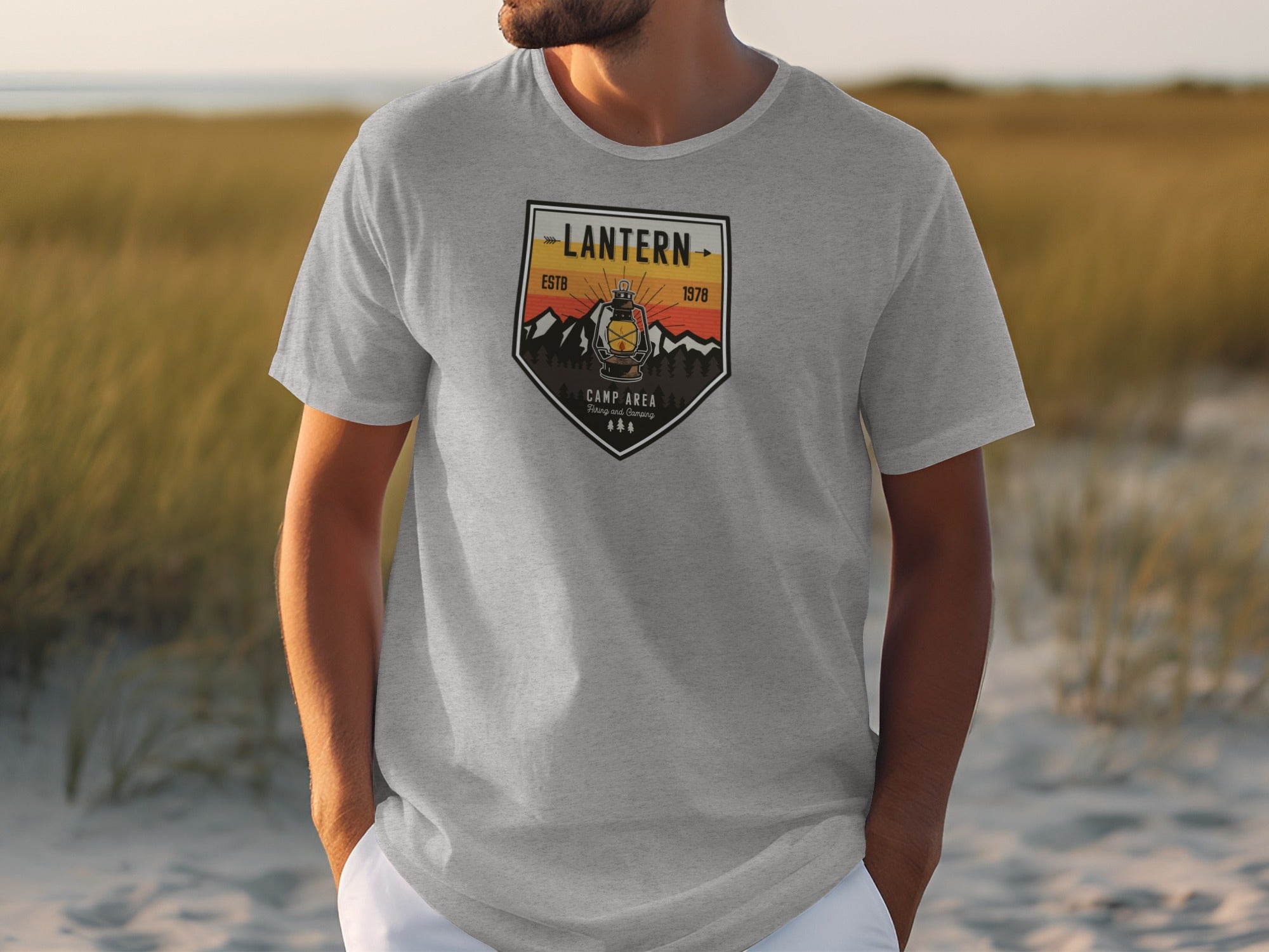 Light gray t-shirt with a shield-shaped graphic featuring a lantern and mountains.