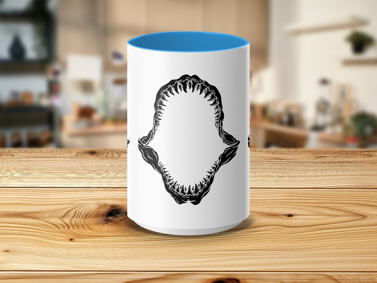 White mug with blue interior and black shark jaw graphic.