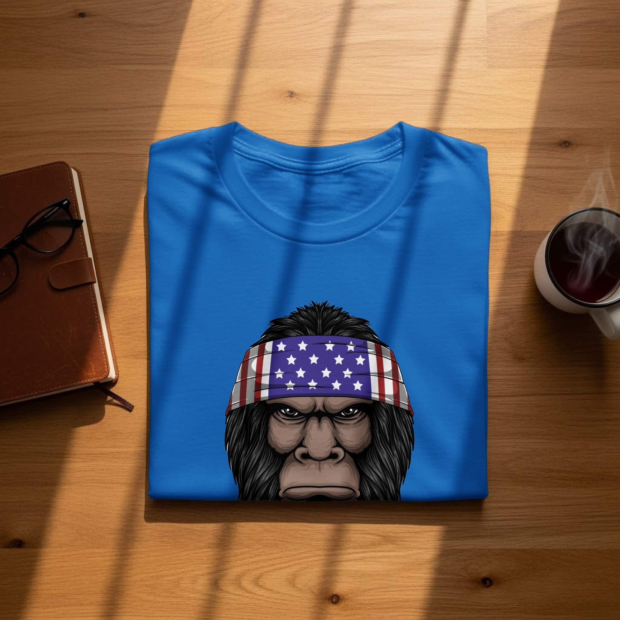 Blue t-shirt with graphic of Bigfoot wearing an American flag bandana