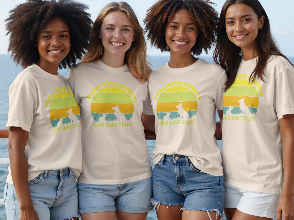 Four women wear cream t-shirts with a circular sunset graphic and text about pets.