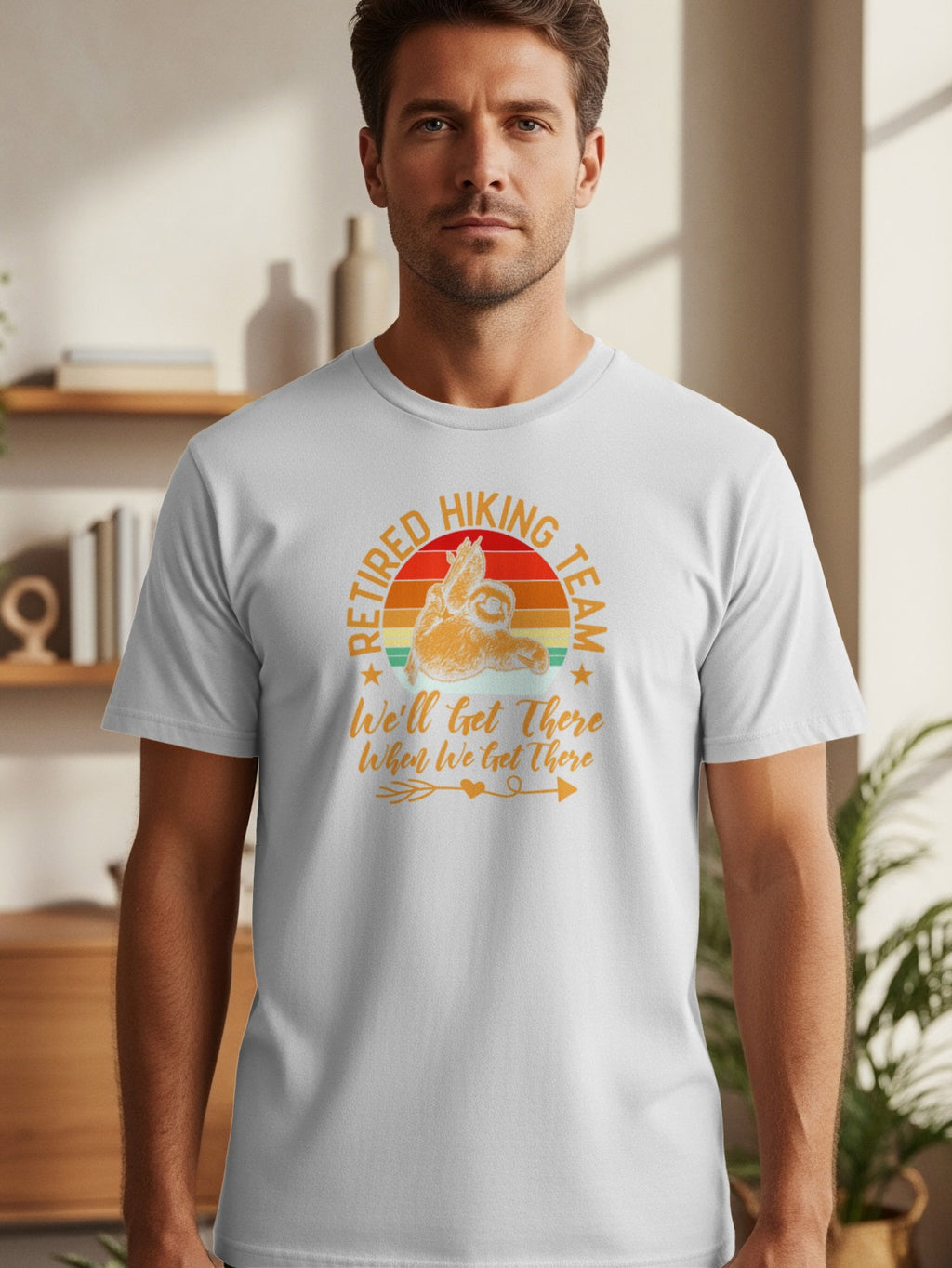 White t-shirt with a sunset graphic of a sloth and text "Retired Hiking Team".