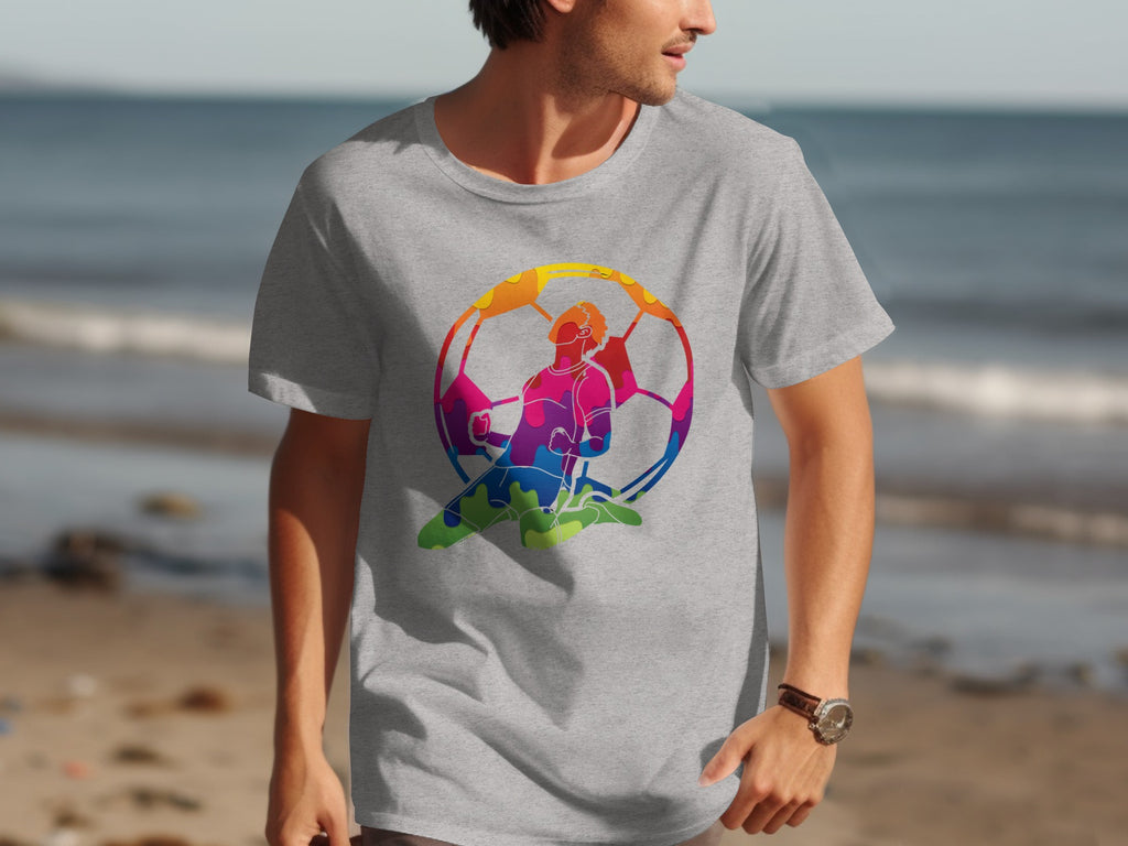 Grey t-shirt with a colorful soccer player design against a beach background.
