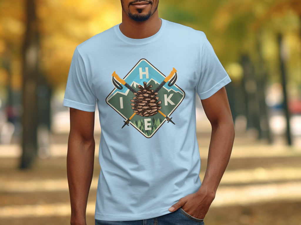 Light blue t-shirt with a diamond graphic of a pinecone, hiking poles, and mountains labeled H I K E.